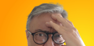 Lic. David Peña Castillo, con anteojos y suéter azul, con mano en la frente mostrando desesperación.