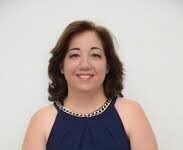 ¡Adiós, Regina Prospero! Una mujer elegantemente vestida con vestido azul, sentada y bien arreglada.