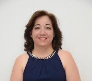 ¡Adiós, Regina Prospero! Una mujer elegantemente vestida con vestido azul, sentada y bien arreglada.